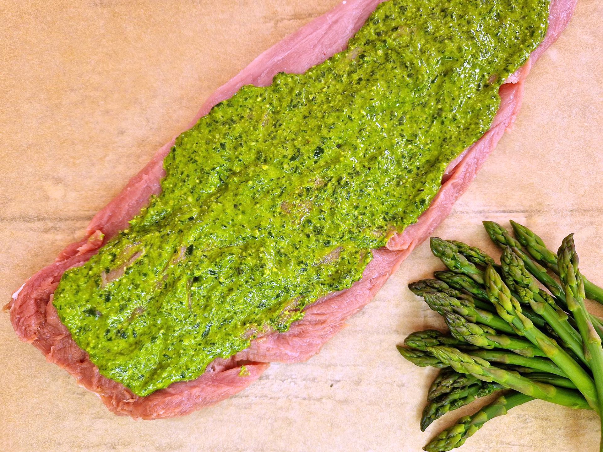 Fleischscheibe mit grünem Pesto bestrichen.