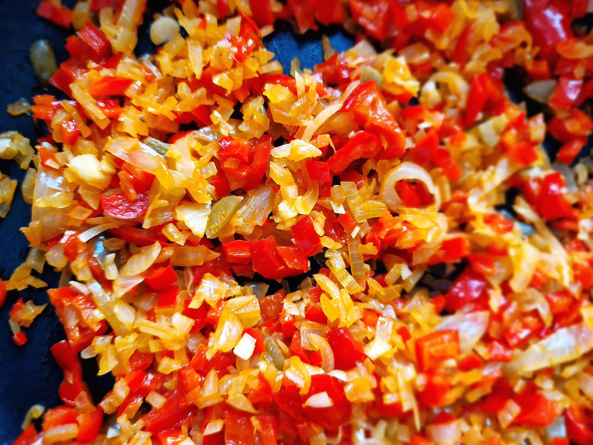 Paprika Zwiebelmischung kleine Würfelchen aus Paprika und Zwiebeln in einer Bratpfanne