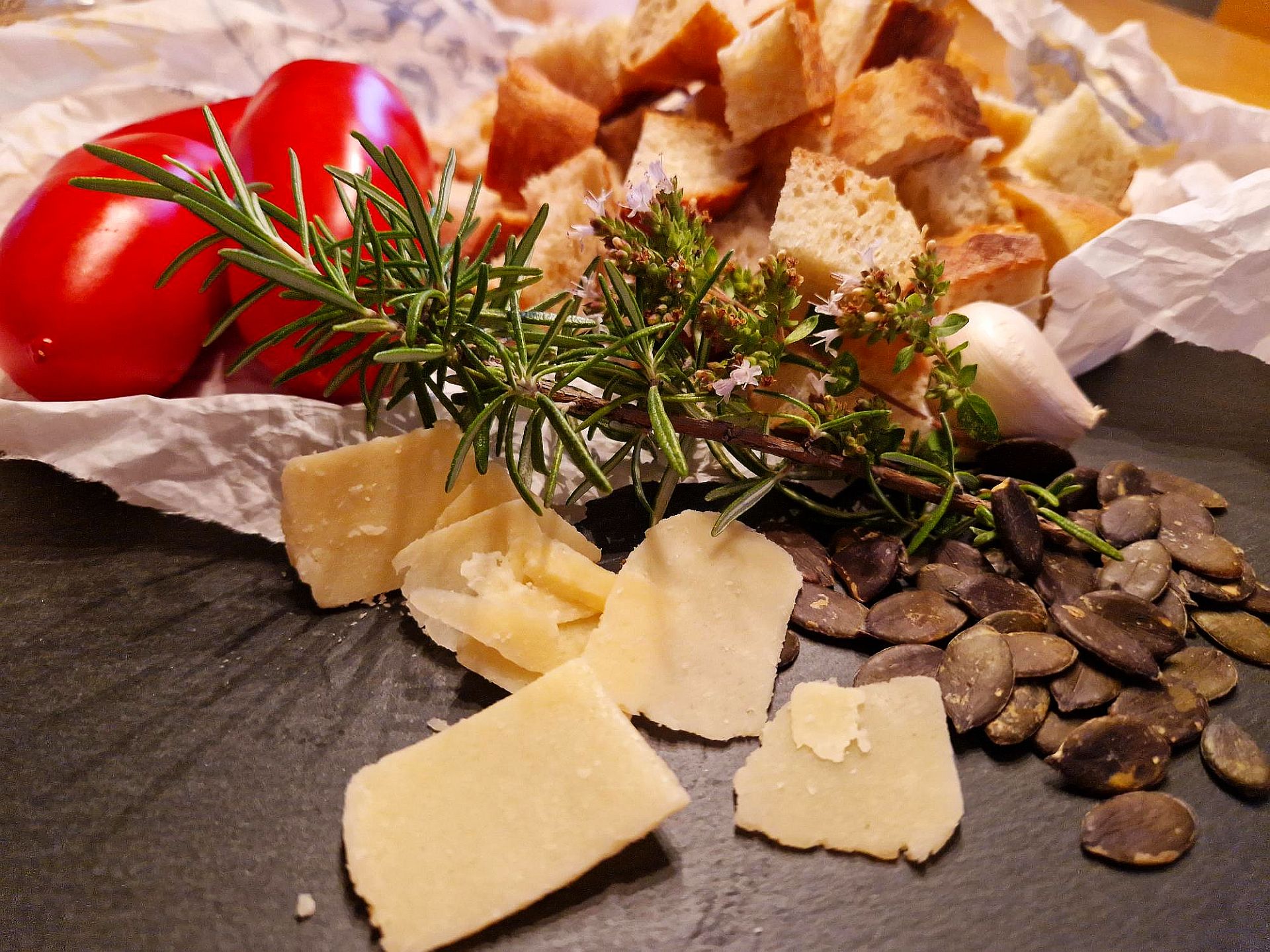 Tomaten, Parmesanspäne, Rosmarinzweig, Kürbiskerne, Knoblauchzehe, Brotwürfel