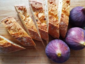 drei frische Feigen liegen neben aufgeschnittenen Baguettescheiben