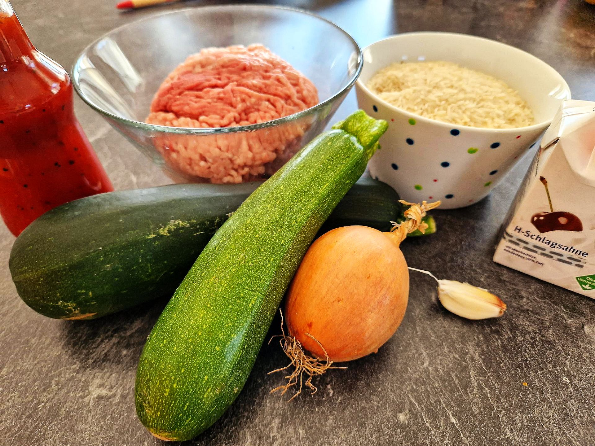 Reis Zutaten 2 Zucchini, Hackfleisch, Zwiebel, Knoblauchzehe, Schlagsahne, Chilisoße, geriebener Käse