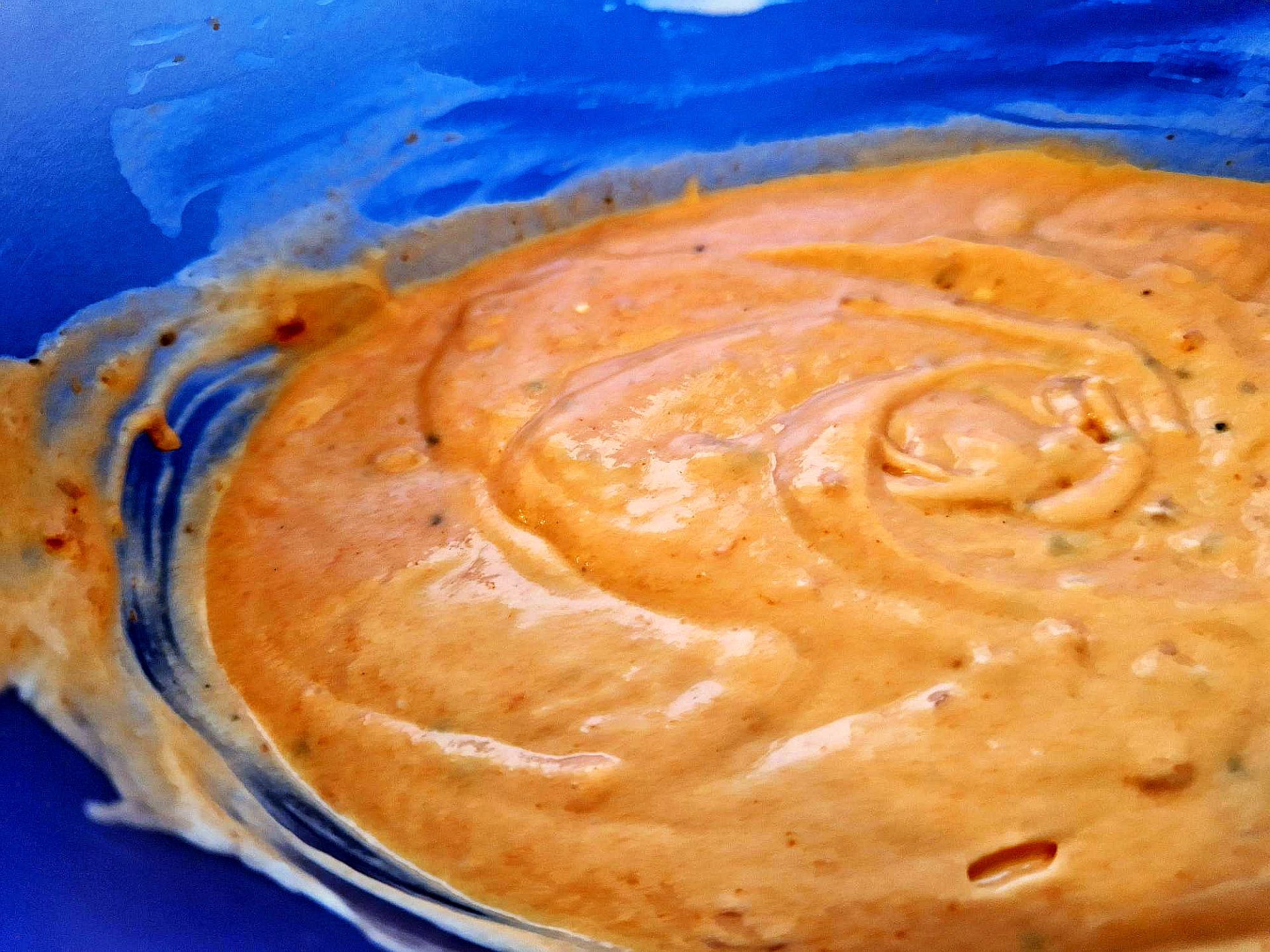 Verquirlte Chili Sahne Mit Schlagsahne verquirlte Chilisoße in blauer Schüssel