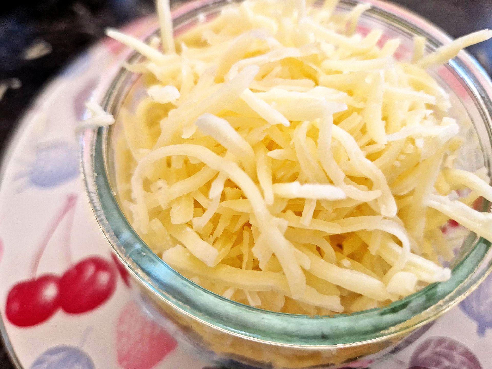 geriebener emmentaler Kleine Glasschüssel mit geriebenem Emmentaler Käse
