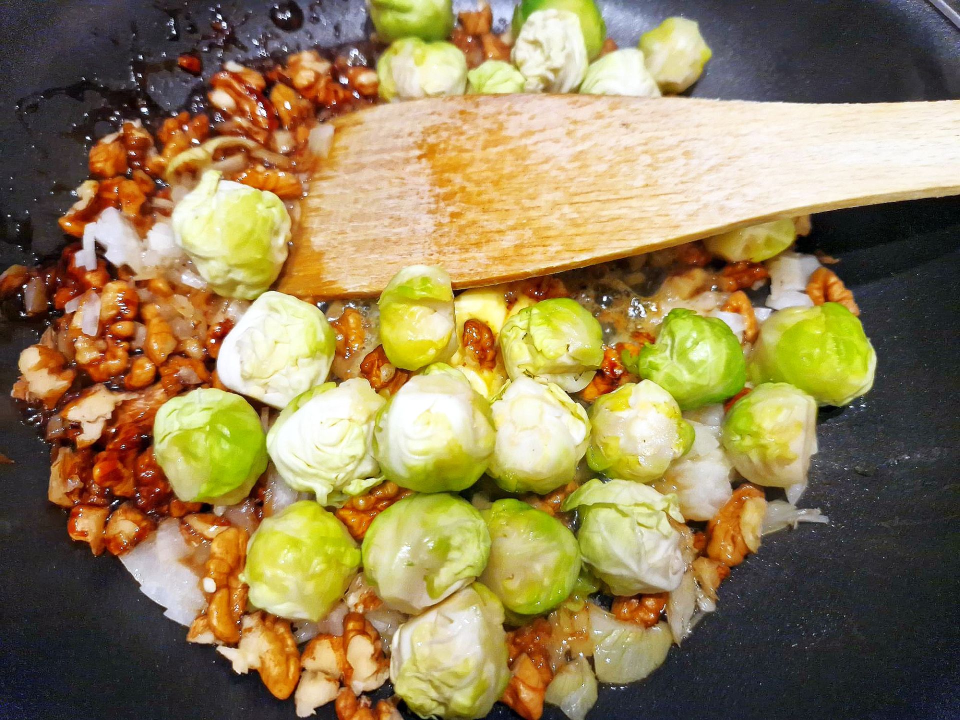 Rosenkohlröschen mit Walnüssen in einer Pfanne
