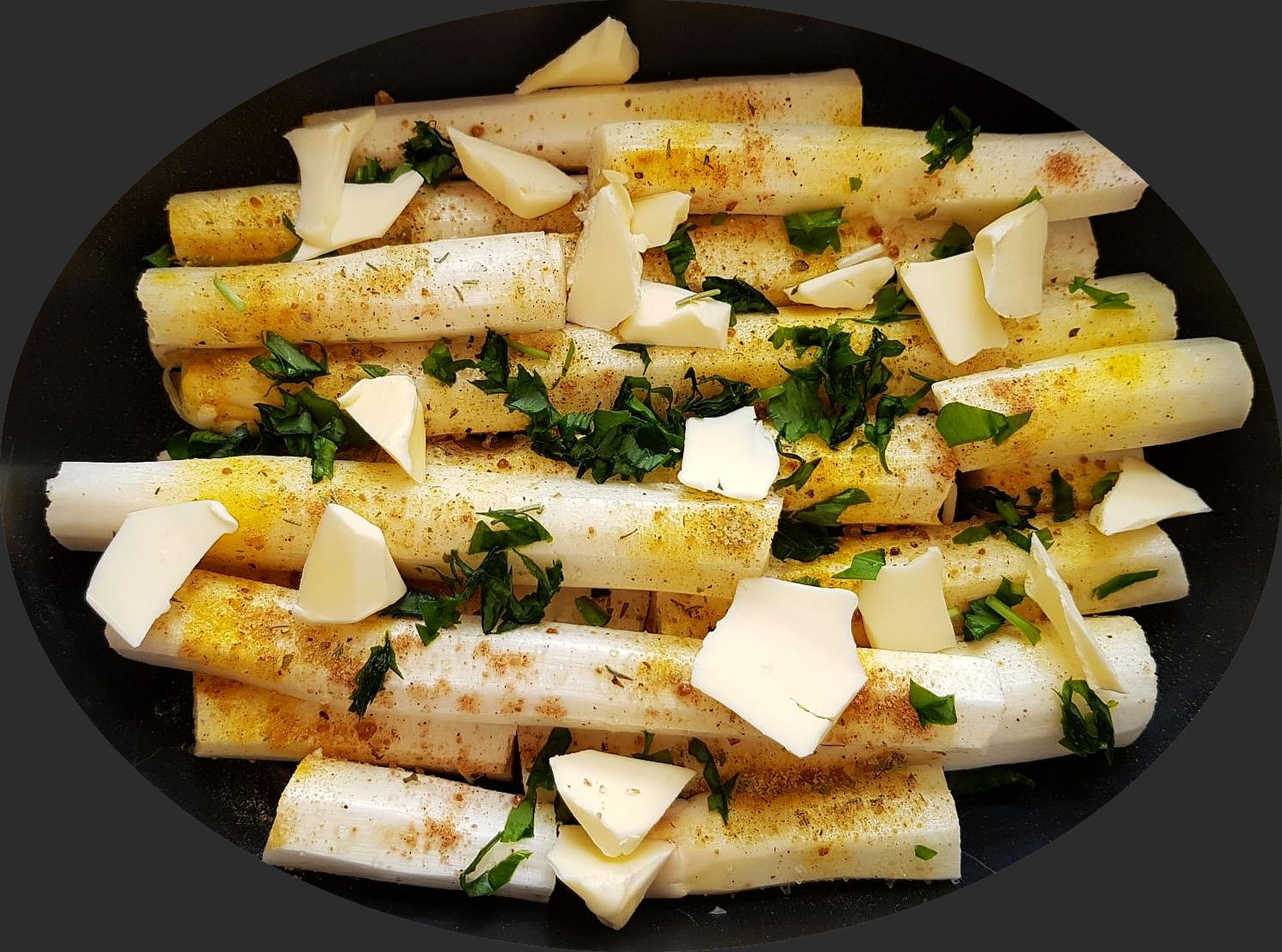 rohe weiße Spargelabschnitte mit Butterflöckchen und Bärlauch im Bräter